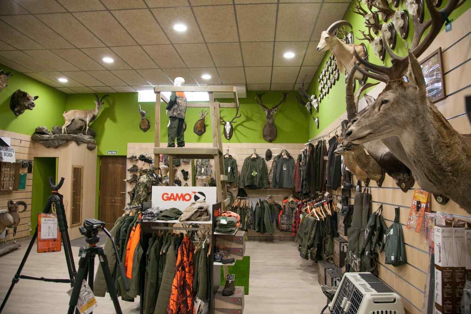 Tienda de artículos de caza con cabezas de animales montadas y equipo de caza a la venta.