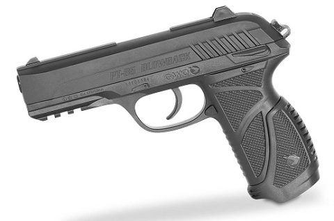 Pistola negra, posiblemente pistola de aire comprimido, colocada en ángulo sobre una superficie blanca.