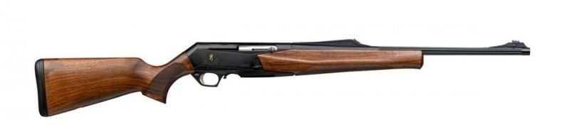 Un rifle con culata de madera, cañón negro y receptor, inclinado hacia la derecha sobre un fondo blanco.