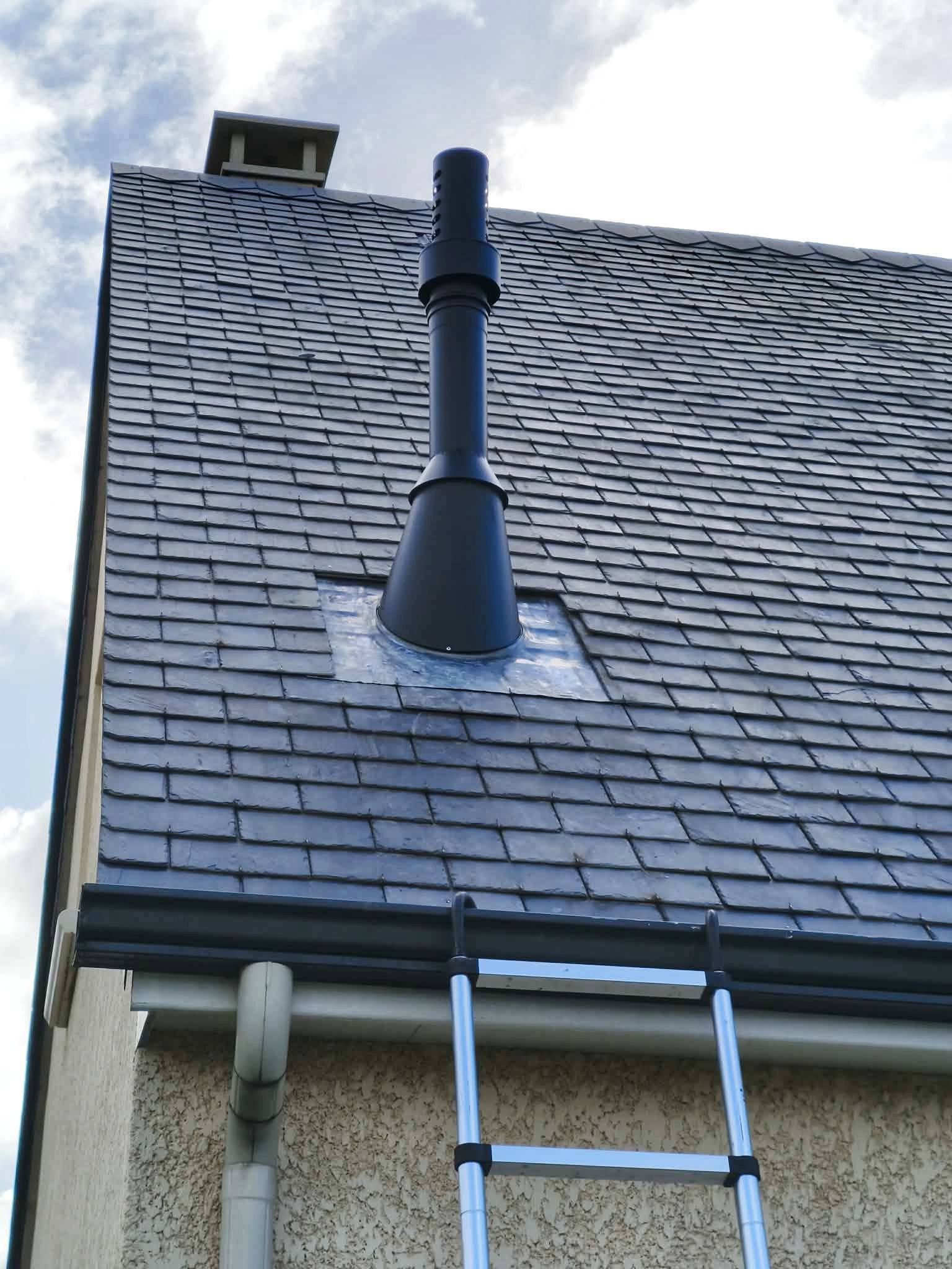 Toit en bardeaux noirs, un tuyau de ventilation et une échelle appuyée contre la maison sous un ciel nuageux.