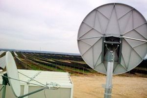 Una gran antena parabólica está situada encima de un edificio.