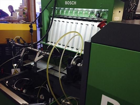 Una máquina Bosch verde con muchos cables saliendo de ella.