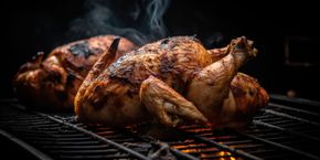 Dos pollos asados ​​en una parrilla, oscuros y ahumados.