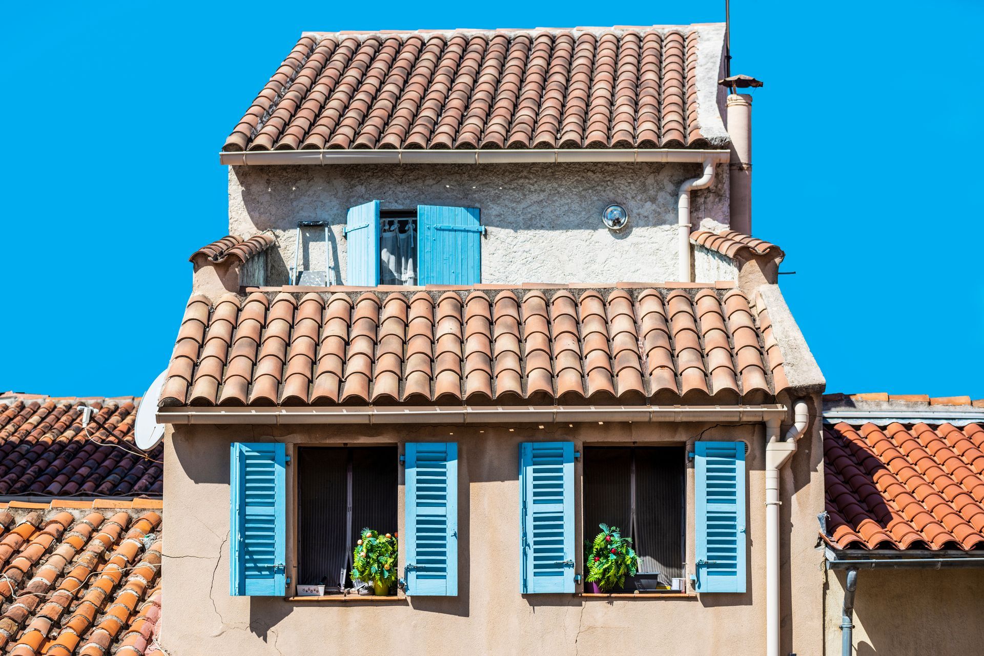 Maison sur plusieurs niveaux avec des volets bleu ciel.