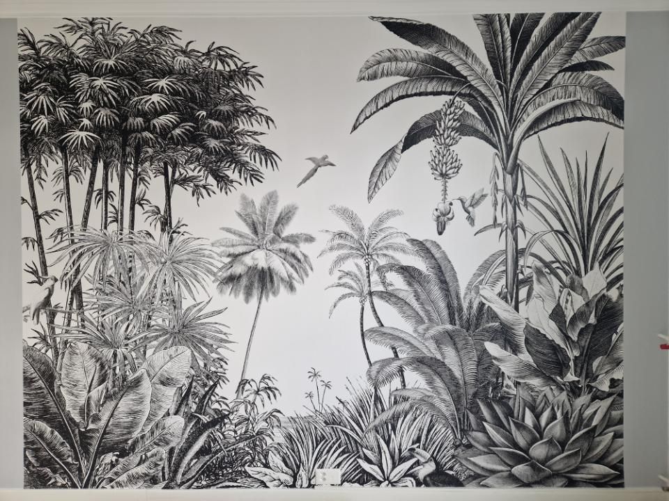 Une peinture en noir et blanc d'une jungle avec des palmiers et des oiseaux.