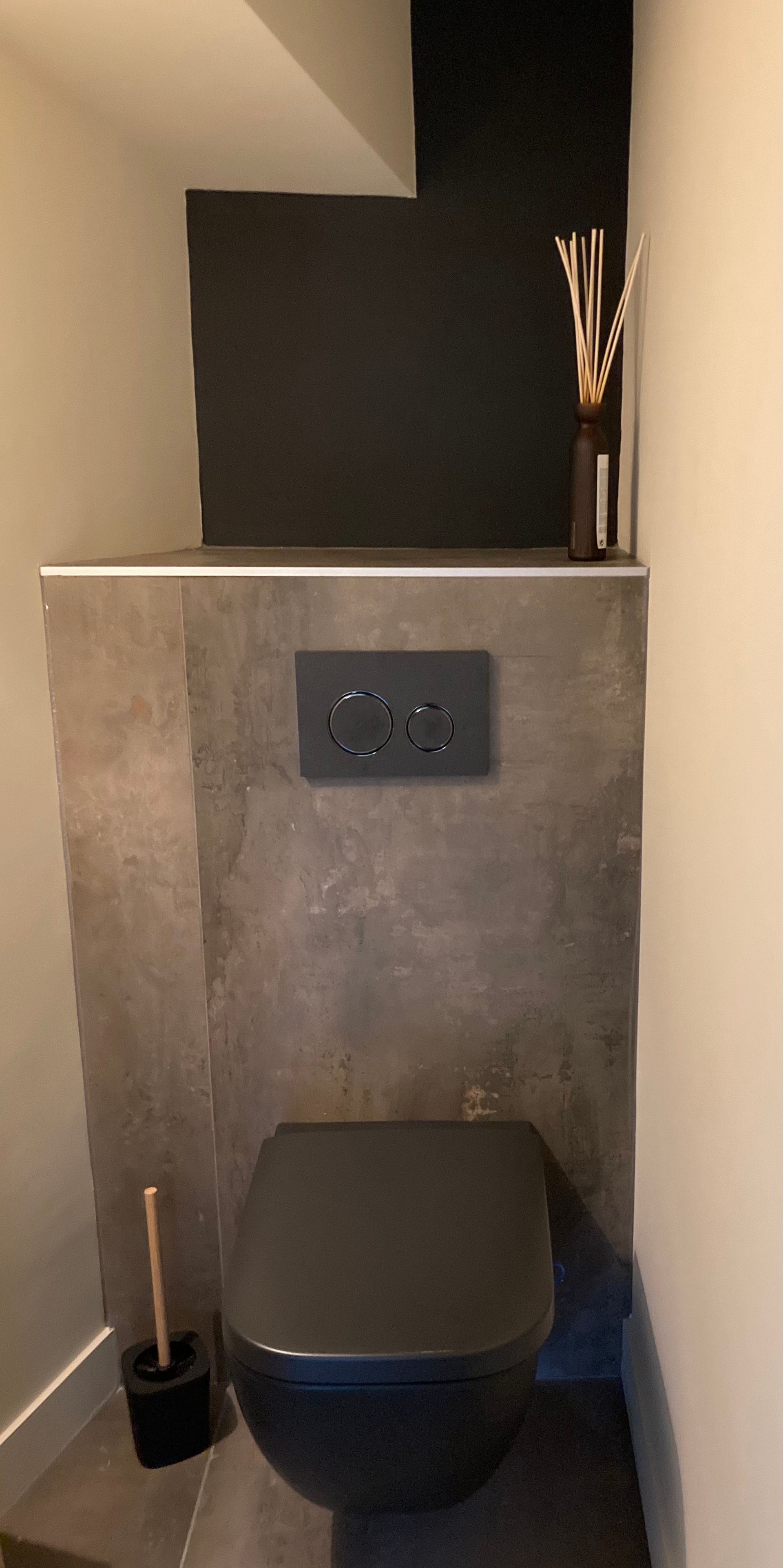 WC noir installé sur un mur en imitation marbre