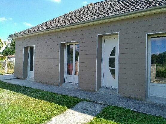 Maison de plain-pied avec une façade en bardage en bois