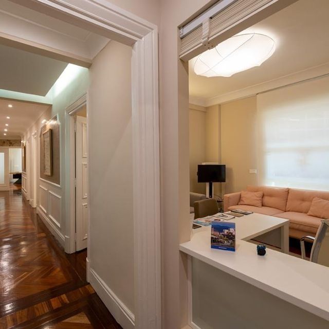 Una sala de estar con un sofá rosa y una mesa blanca.