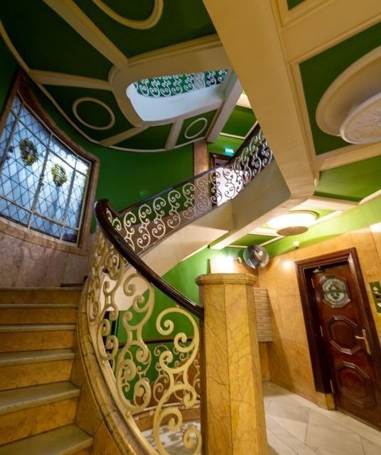 Una escalera de caracol en un edificio con techo verde.