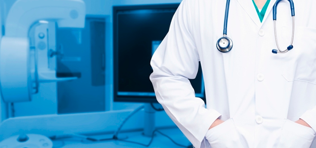 Un médico con un estetoscopio alrededor del cuello está de pie en una habitación de hospital.