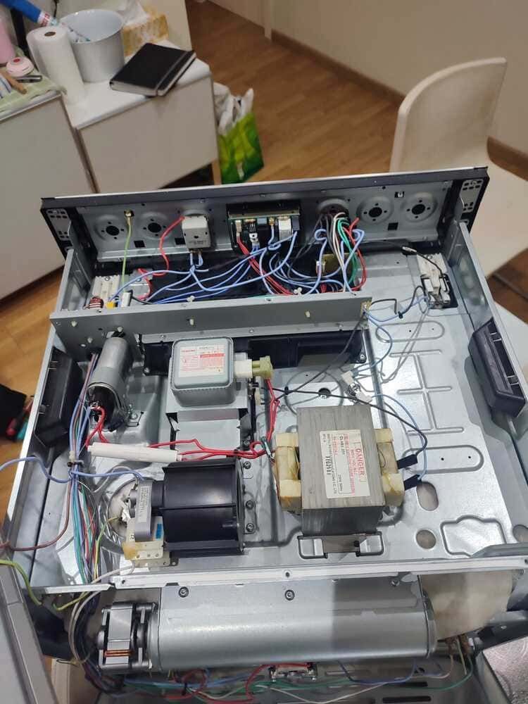 Equipo electrónico abierto con cableado y componentes expuestos sobre una mesa, visto desde arriba.
