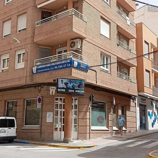Una camioneta blanca está estacionada frente a un consultorio dental.