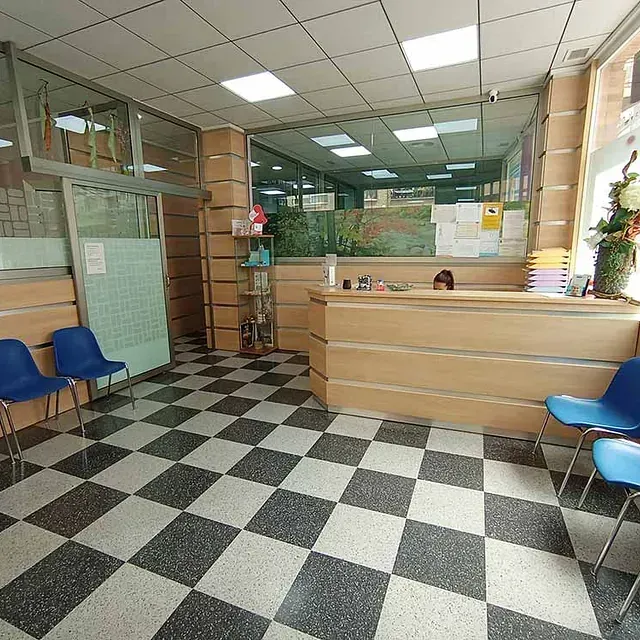 Una sala de espera con suelo a cuadros y sillas