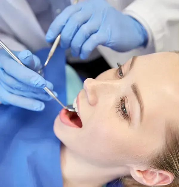 Una mujer está siendo examinada por un dentista.