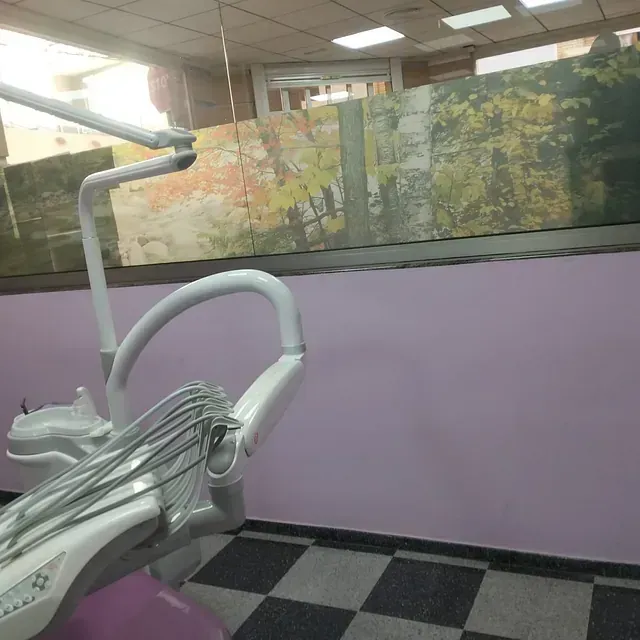 Un consultorio dental con una pared morada y un sillón dental.