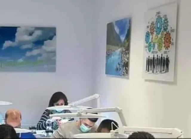 Un grupo de personas está sentado en una habitación con pinturas en la pared.