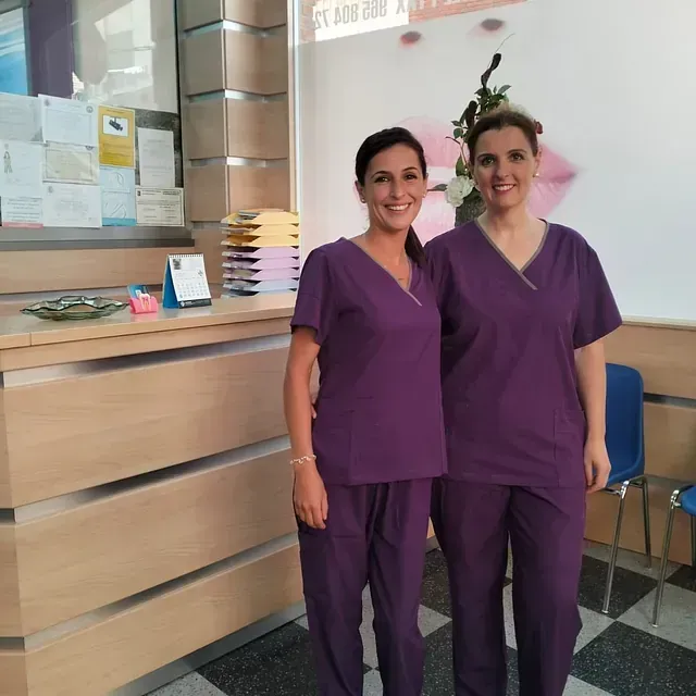 Dos mujeres con uniformes morados están una al lado de la otra