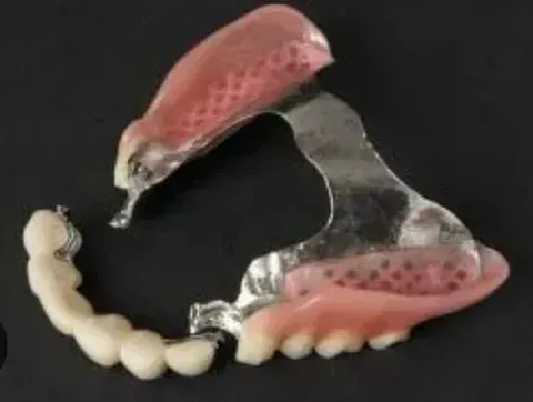 Una dentadura postiza está colocada encima de una mesa negra.