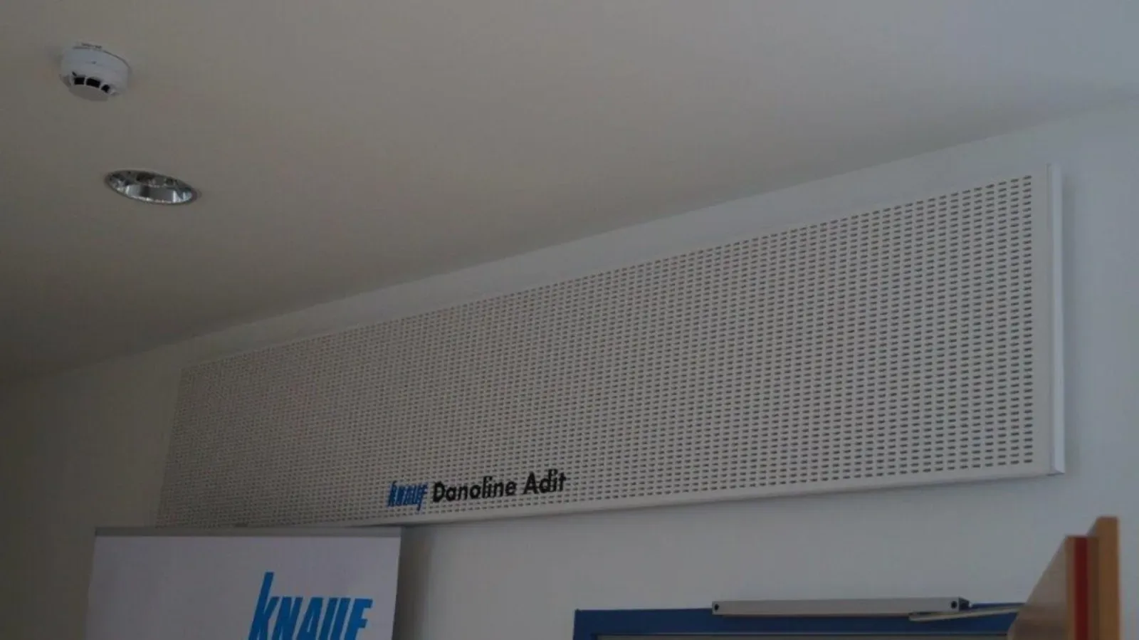 Weißes, perforiertes Wandschild mit der Aufschrift „Domestic Hub“ über einer Tür in einem Flur.