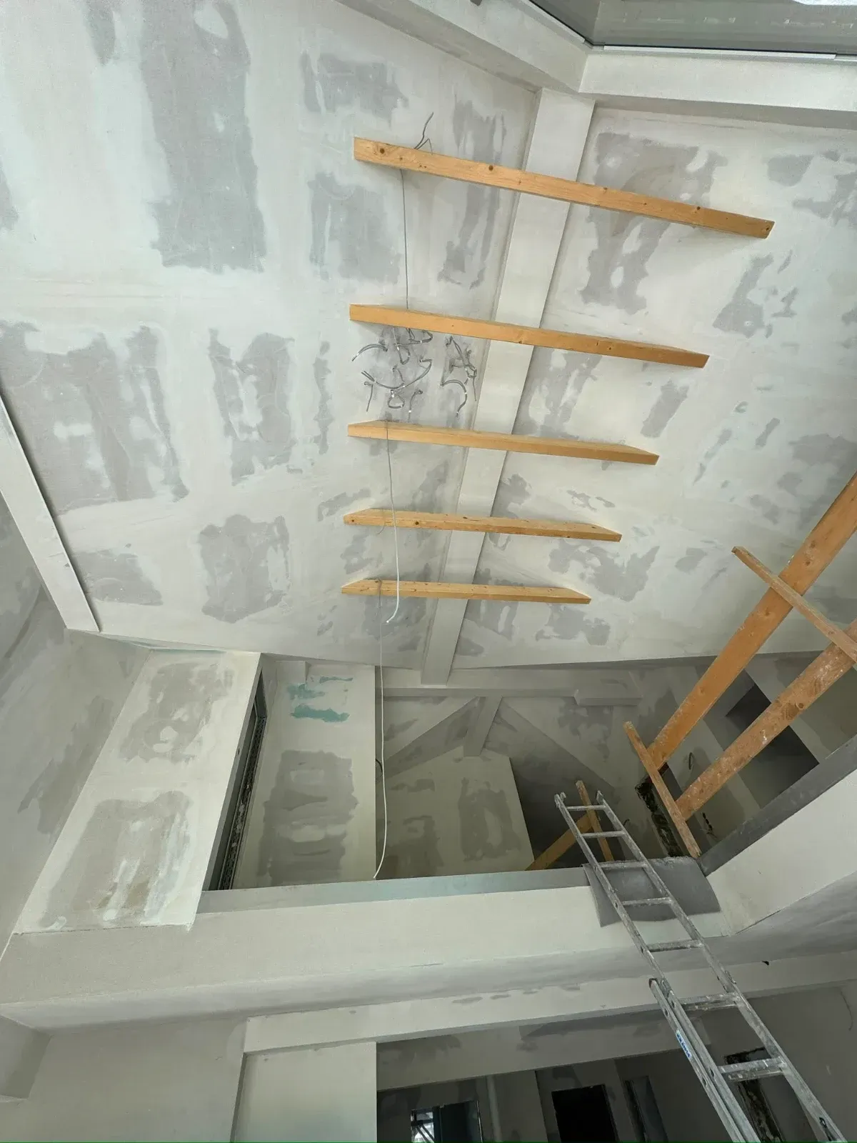 Die Decke wird renoviert und besteht aus hölzernen Leitersprossen und einer darunter stehenden Metallleiter.