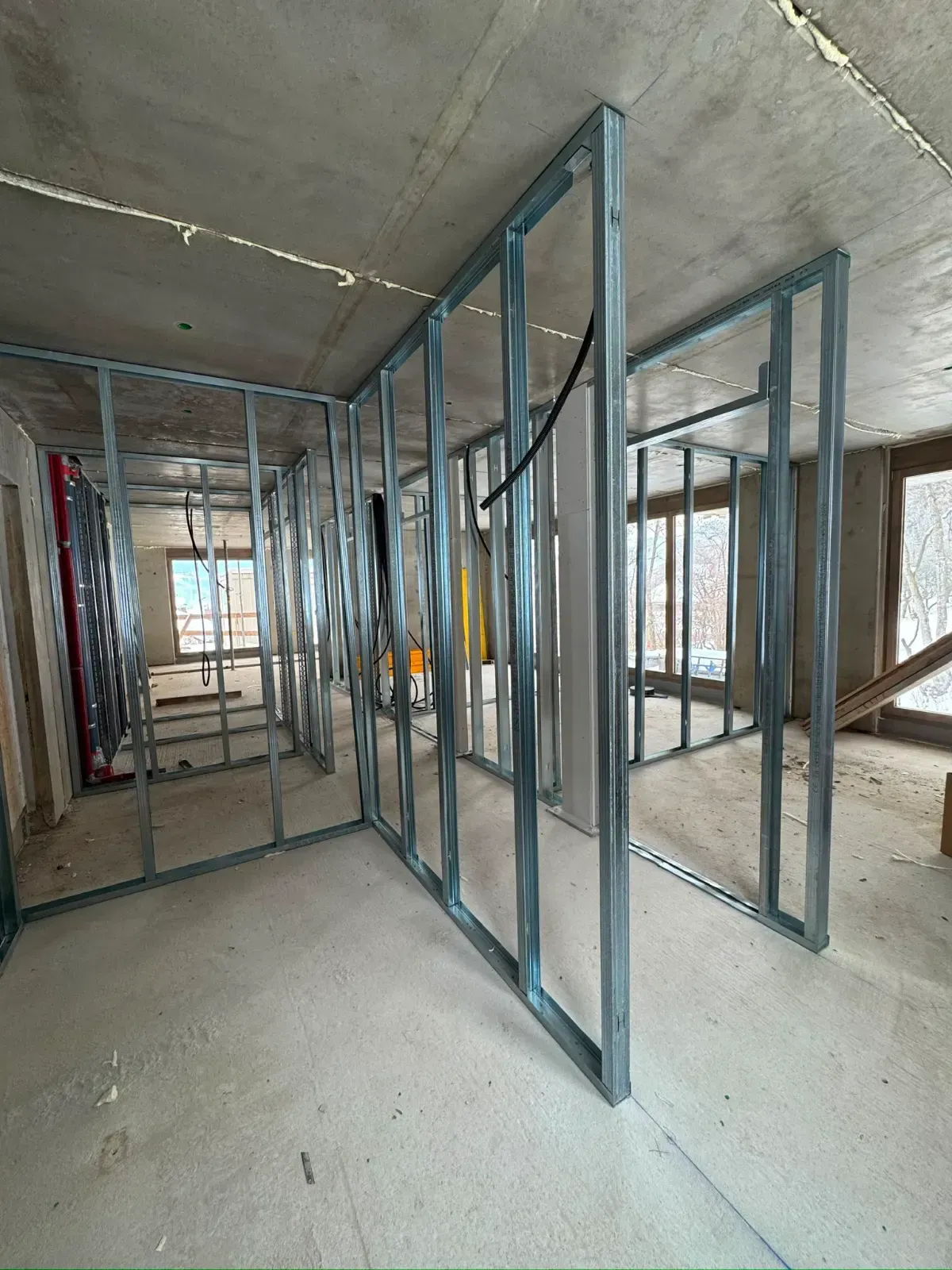 Innenansicht eines im Bau befindlichen Gebäudes mit Metallwandständern und Betonböden und -decke