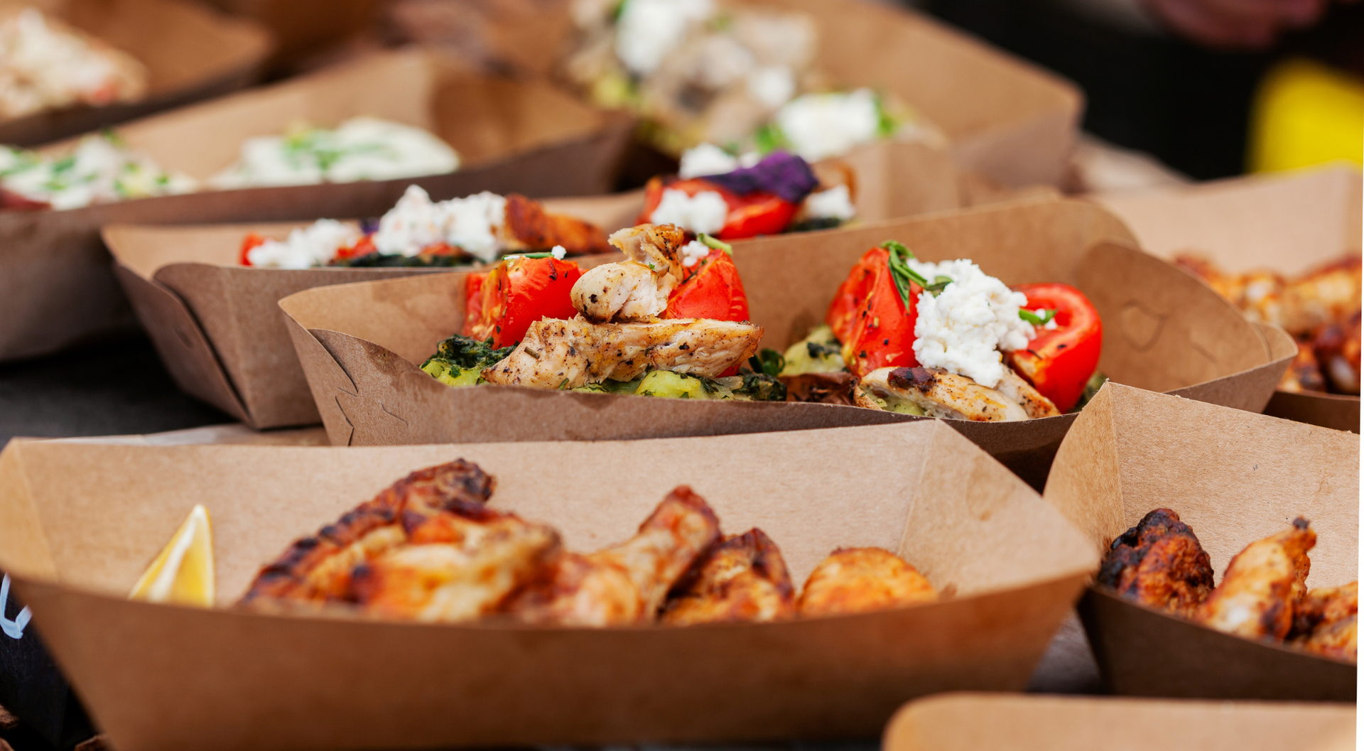 Bandejas de comida con pollo asado y otros platos preparados.