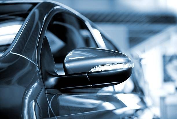 Un primer plano del espejo lateral de un automóvil en un estacionamiento.