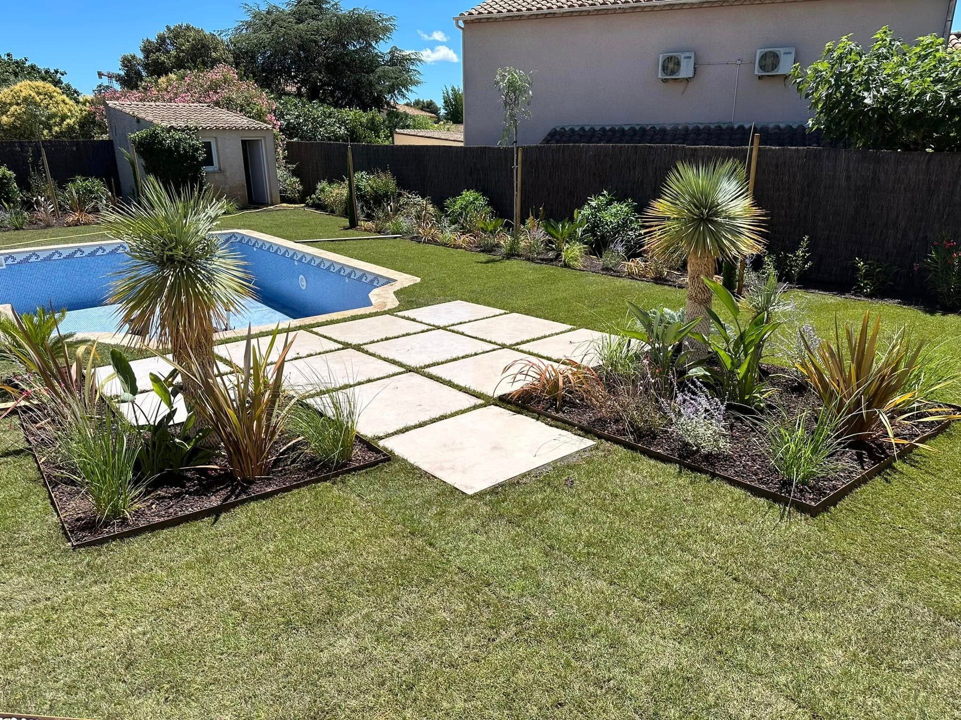 Une allée dans un grand jardin avec arbustes
