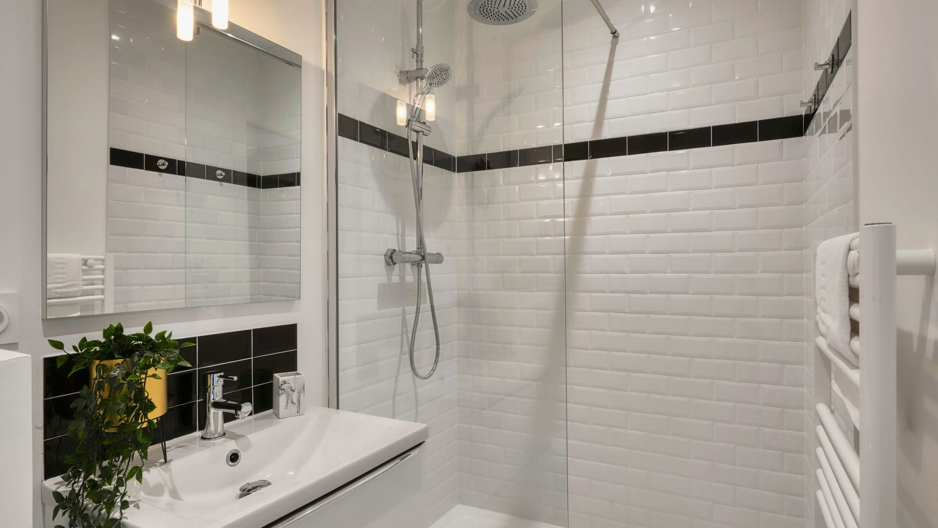 Une salle de bains avec du carrelage blanc et noir