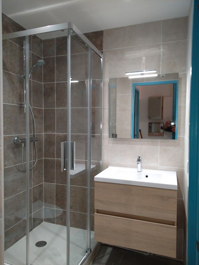 Une salle de bains avec une douche avec du carrelage gris