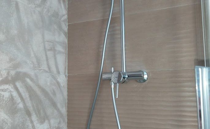 Une douche avec du carrelage avec un motif