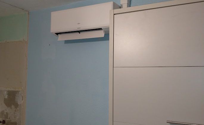 Un climatiseur mural sur un mur bleu