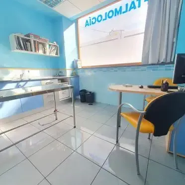 Una habitación con una mesa y sillas y una ventana.