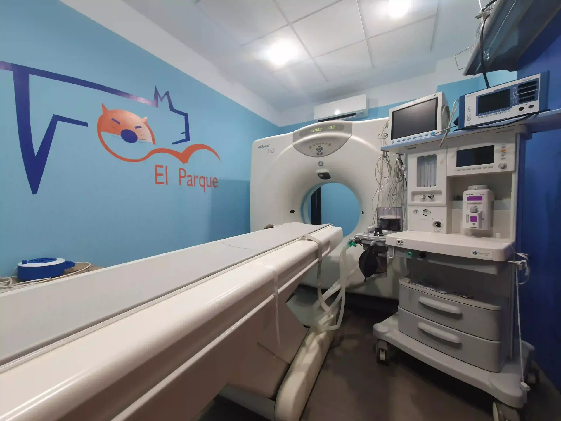 Una habitación de hospital con una máquina de tomografía computarizada y una mesa de operaciones