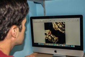 Un hombre está mirando una imagen en la pantalla de una computadora.