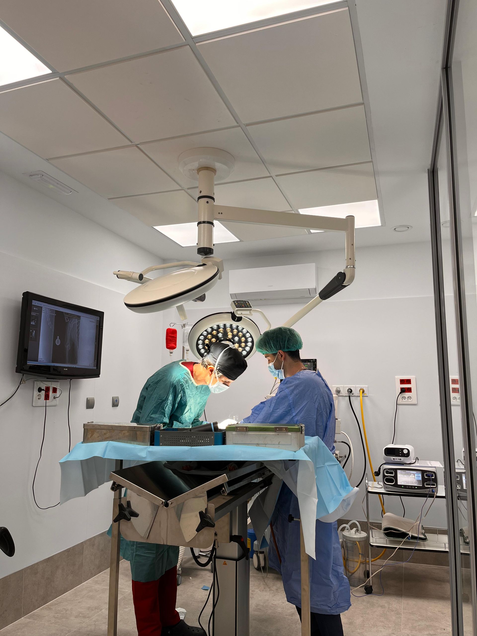 Dos cirujanos están operando a un paciente en un quirófano.