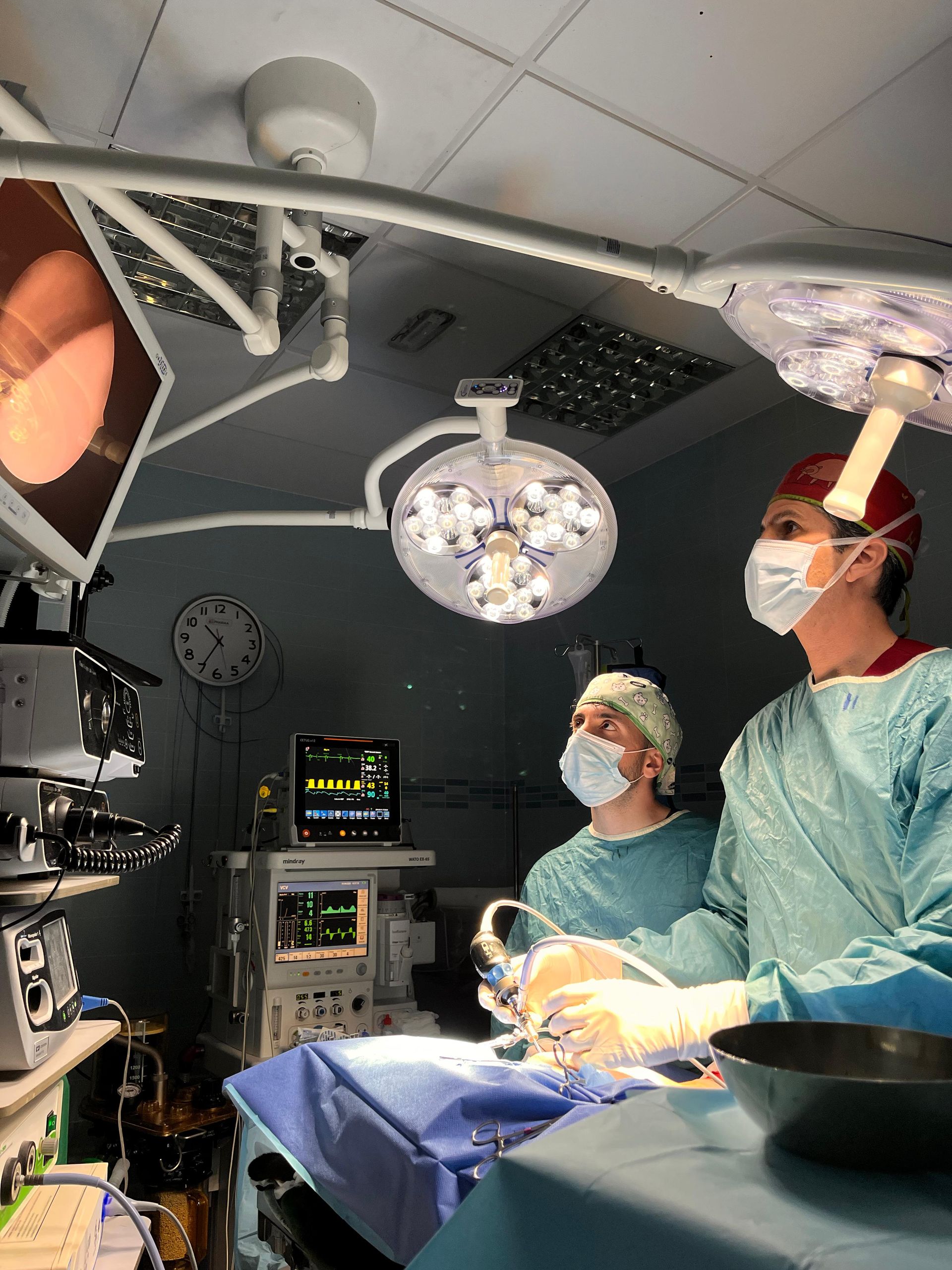 Dos cirujanos están operando a un paciente en un quirófano.