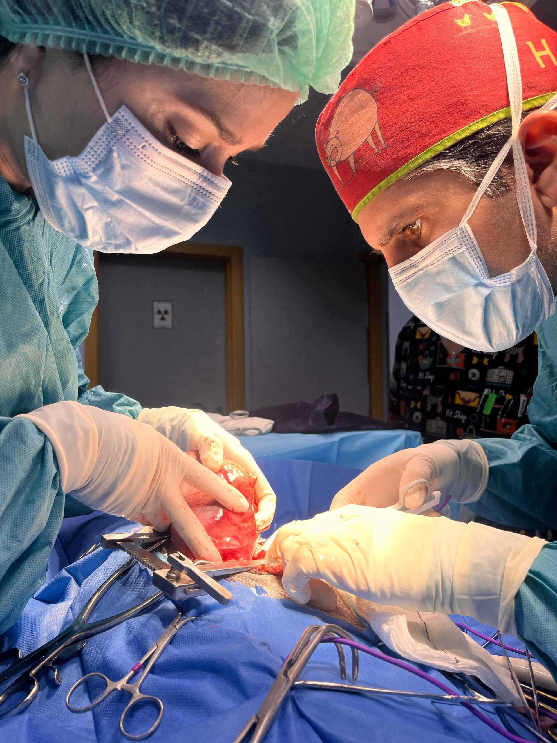 Dos cirujanos están operando a un paciente en un quirófano.