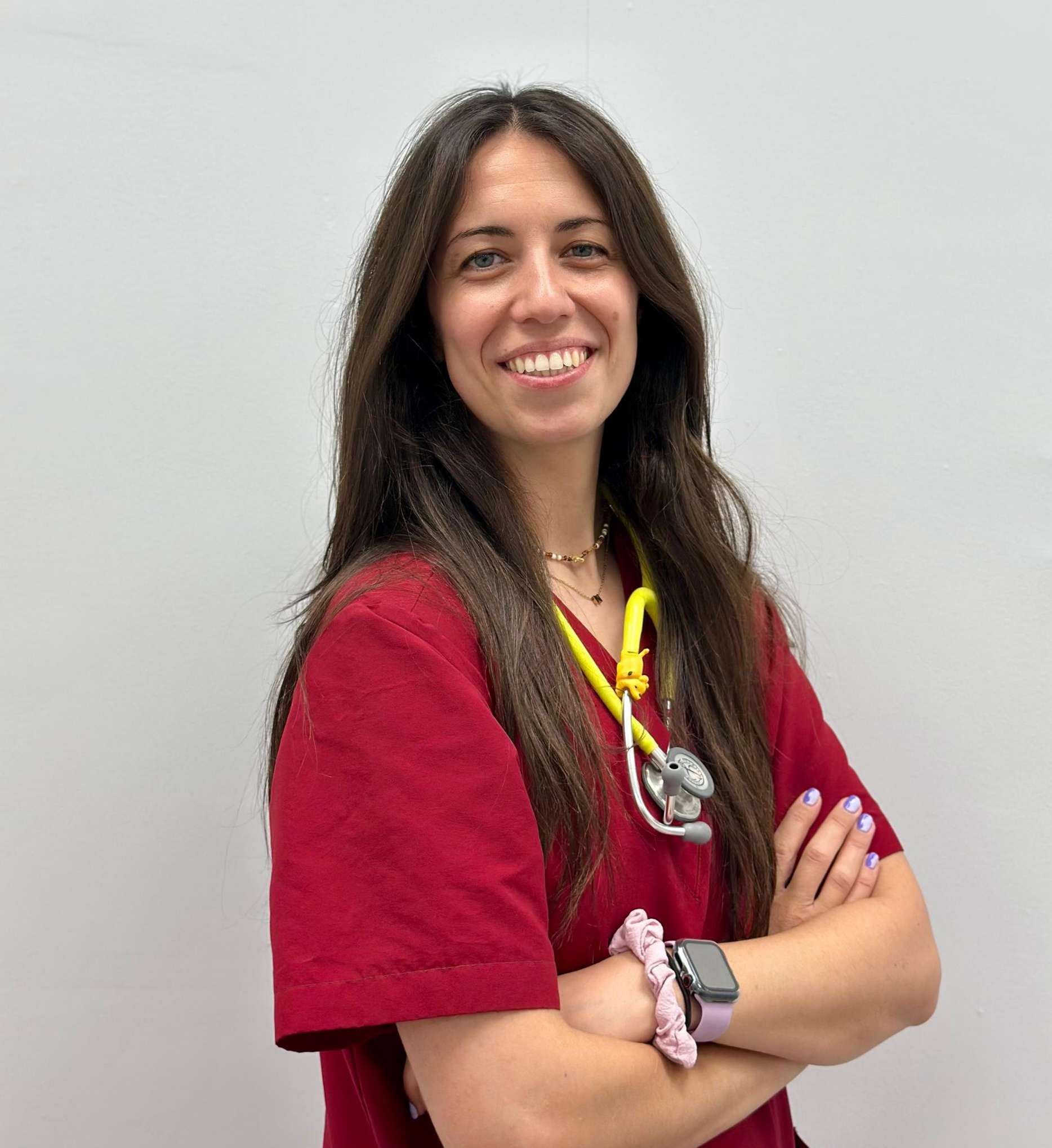 Una mujer con una blusa roja sonríe para la cámara.