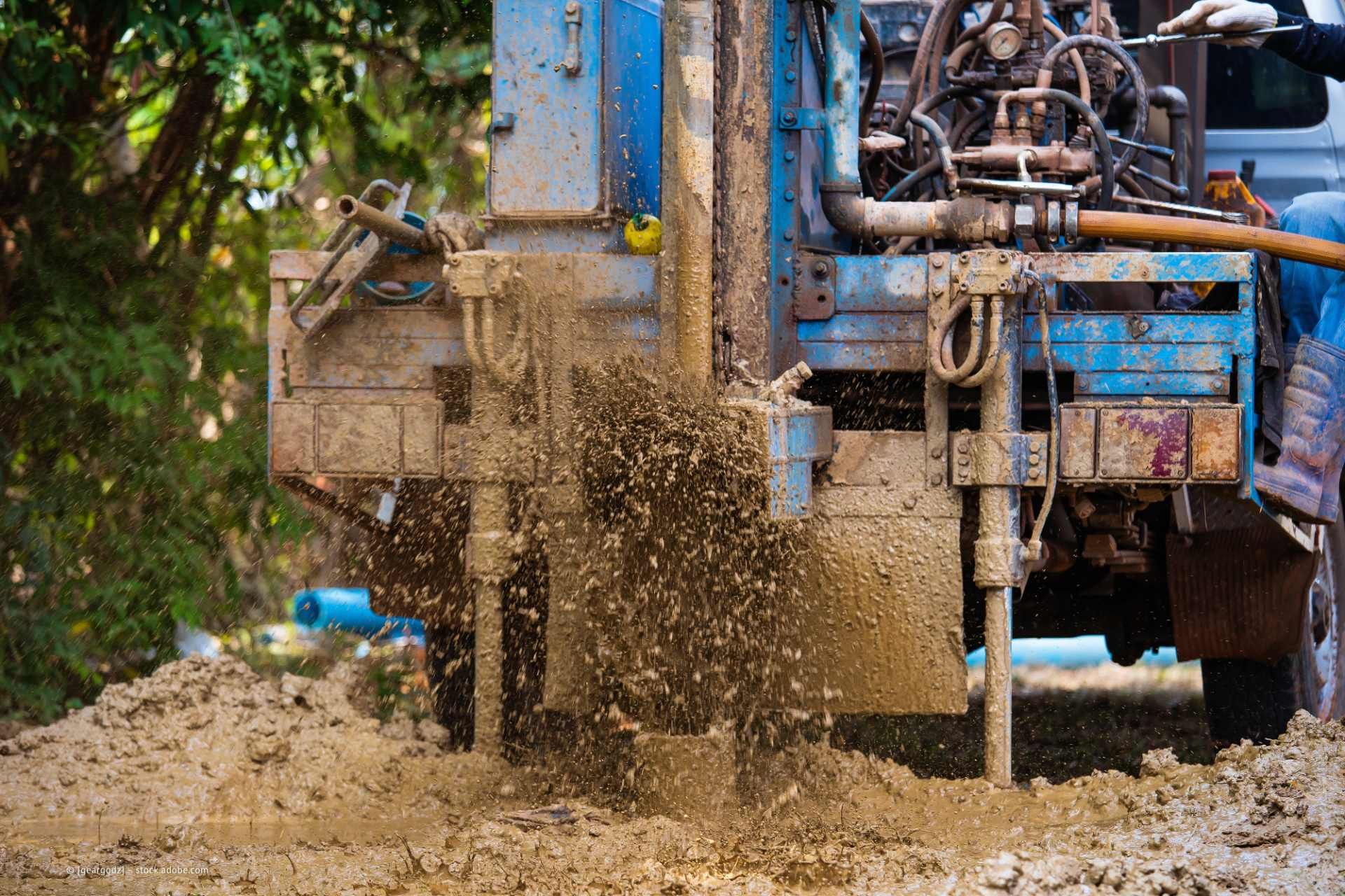 Bohrinsel im Einsatz; Schlammspritzen. Blaue Maschine, brauner Schlamm. Draußen.