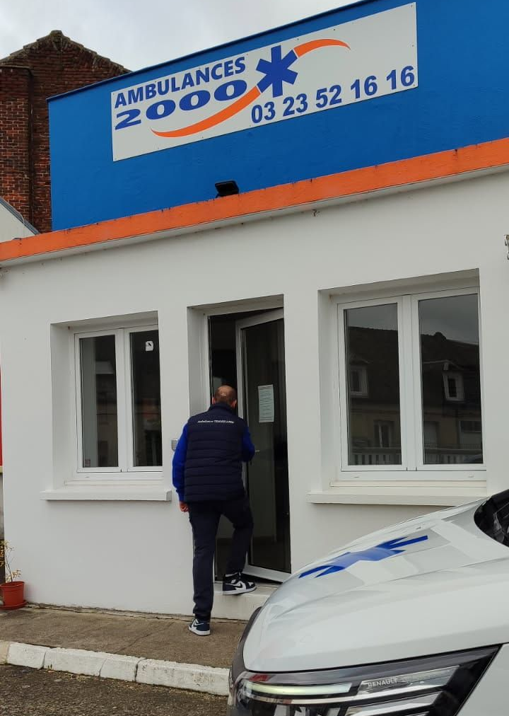 Un homme entre dans le bâtiment Ambulances 2000 . 