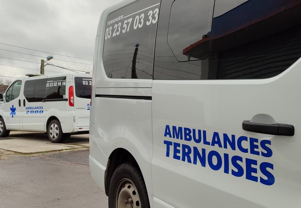 Deux ambulances blanches stationnées dans une rue.