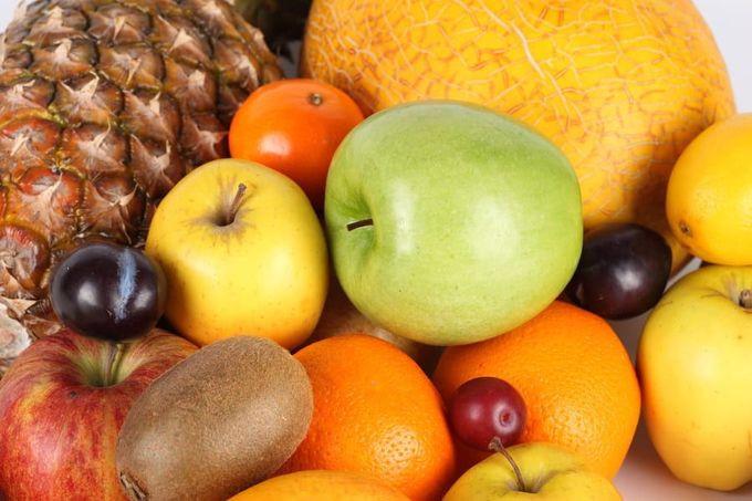 Una variedad de frutas se apilan una encima de otra sobre una mesa.