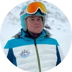 Una mujer que lleva casco y gafas protectoras está parada en la nieve.