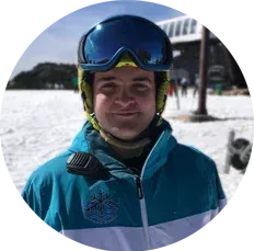Un hombre que lleva casco y gafas protectoras está de pie en la nieve.