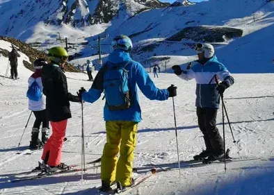 Un grupo de personas está esquiando por una pendiente cubierta de nieve.