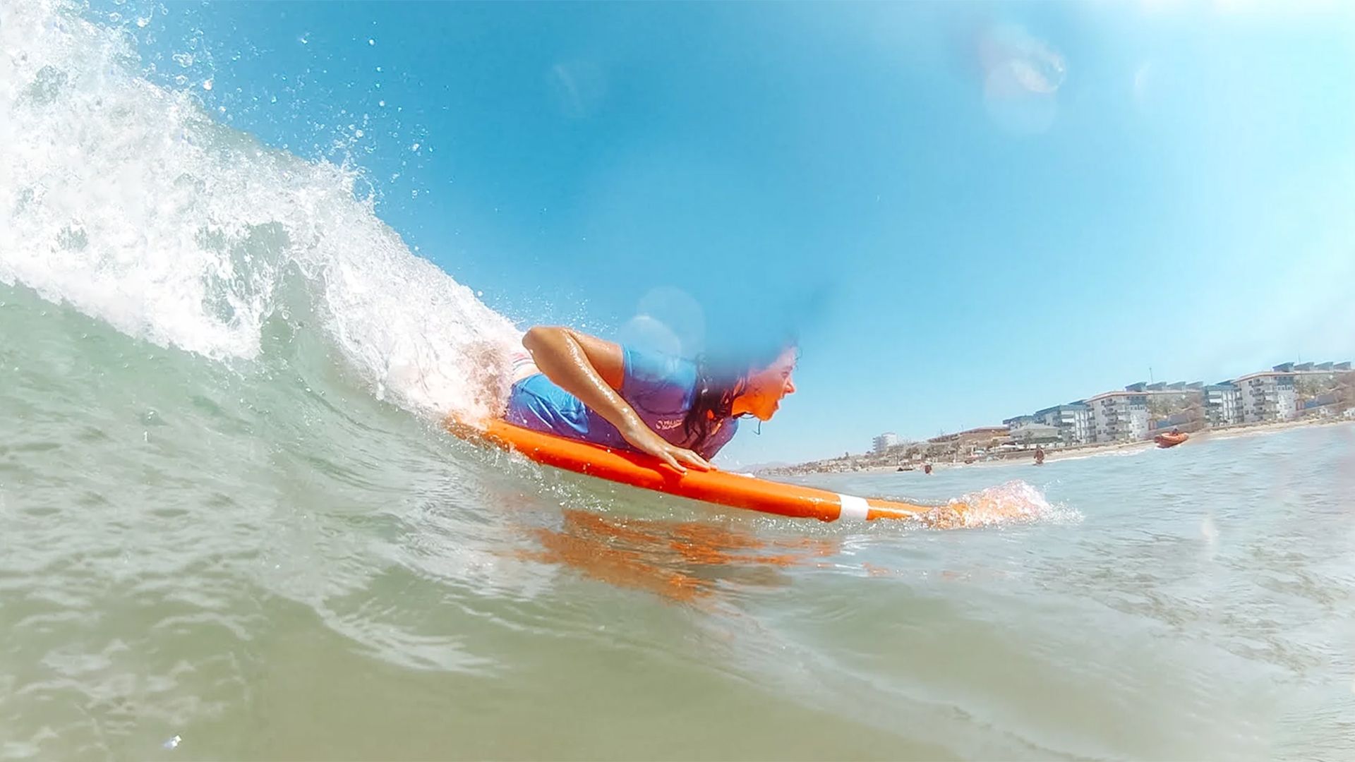 Una persona está montando una ola en una tabla de surf en el océano.