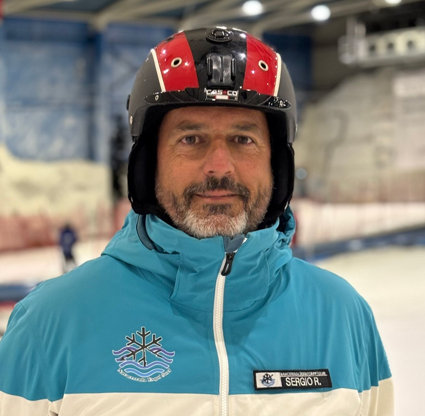 Un hombre que lleva casco y gafas protectoras está de pie en la nieve.
