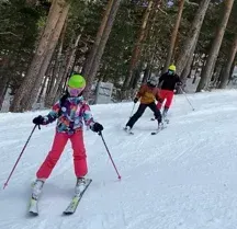 Un grupo de personas está esquiando por una pendiente cubierta de nieve.