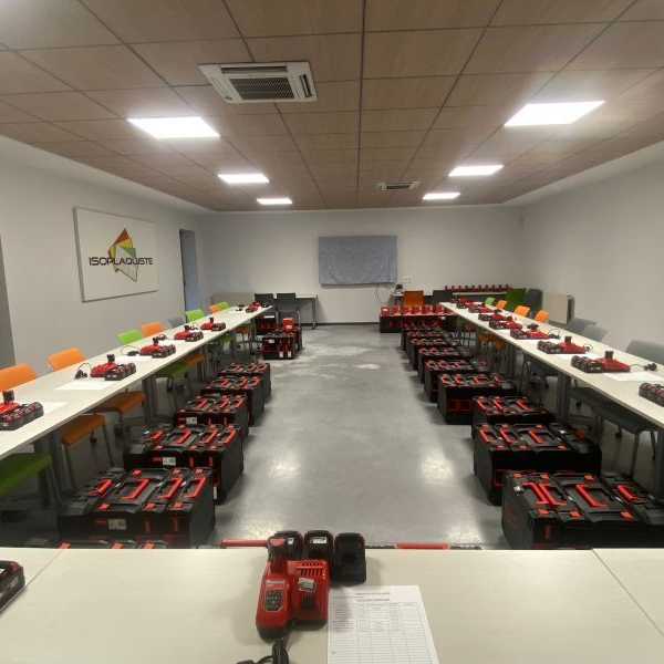 Une salle de réunion avec des rangées de tables, chacune avec des boîtes rouges.